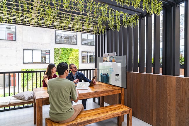 People looking at monitor in outdoor office setting