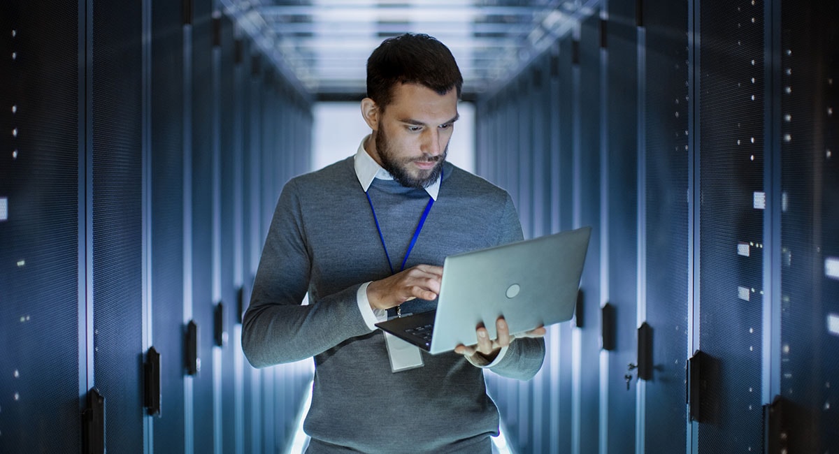 man-on-laptop-in-front-of-server