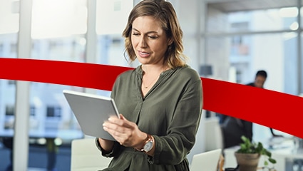 Woman standing in bright office using tablet.