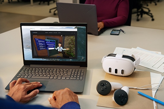 image of a man working on a laptop computer with Meta VR headset on the table next to it