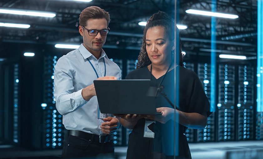 Two coworkers inside a data center.