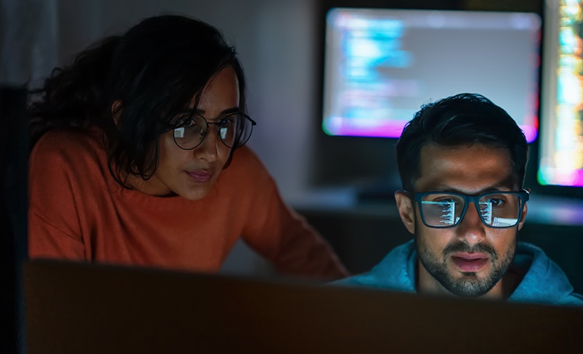 image of two developers working on a shared computer monitor