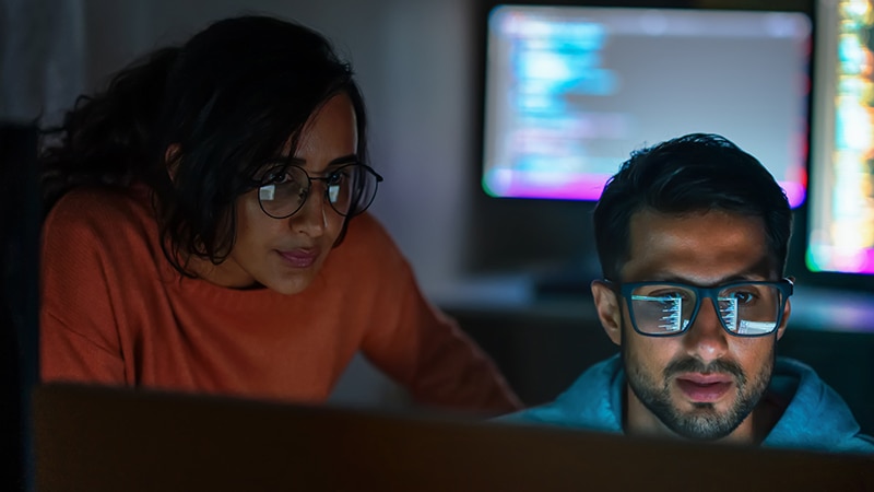 image of two data center employees working on data protection on a shared computer.