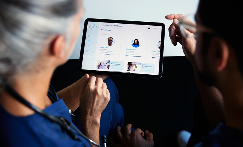 image of a doctor reviewing information on a tablet with a coworker