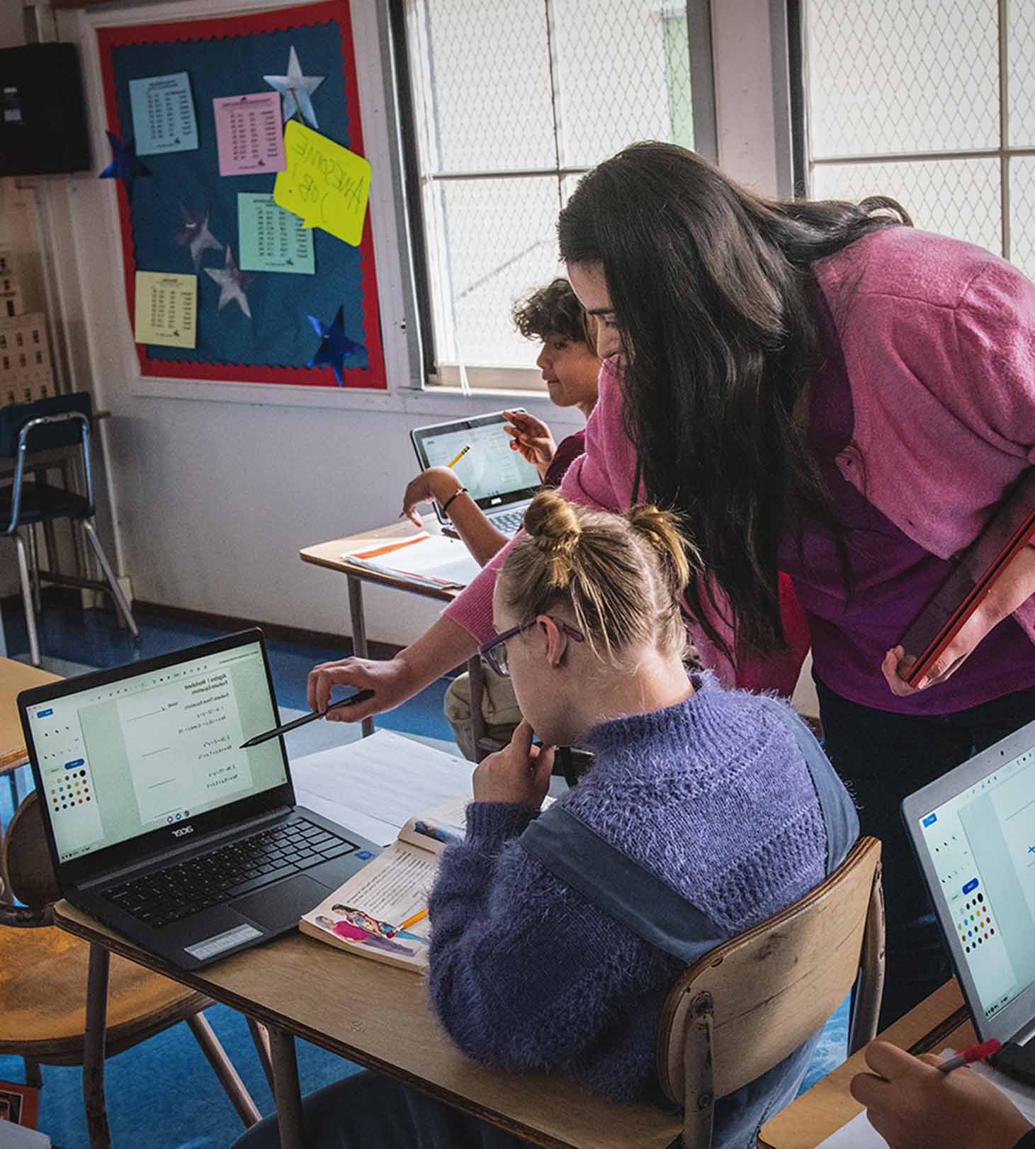 Young students are using laptops in the classroom.