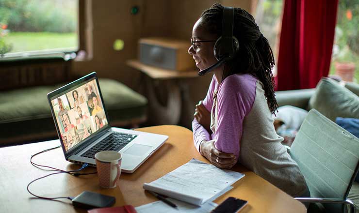Child wears a headset and participates in an online learning session on a laptop