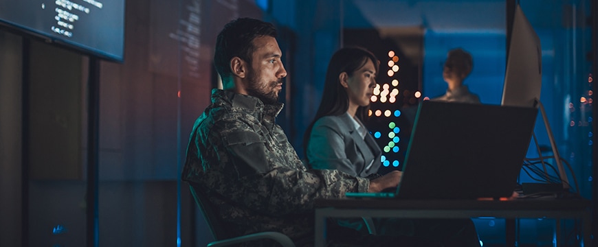 Military and civilian professionals working ion AI Security inside an operations center