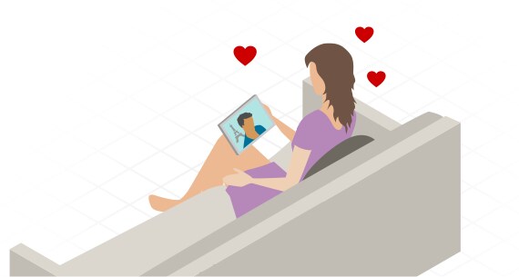 Image of woman sitting on couch using a tablet device to video chat.