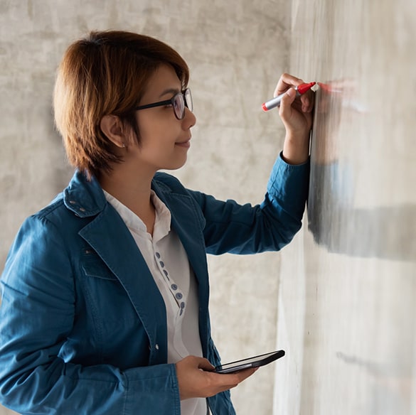 Woman drawing on white board.