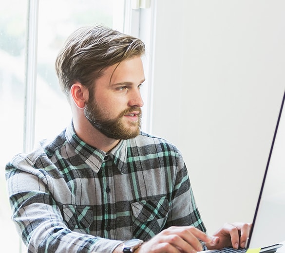 Image of a man working on a laptop.