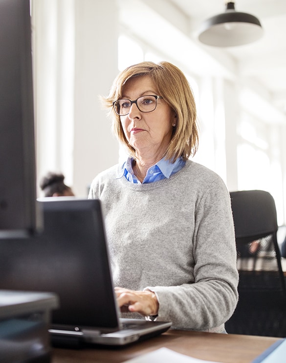 Female teacher working on a laptop.