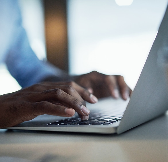 Close up image of person's fingers typing on laptop.