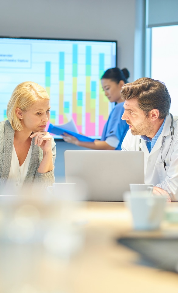 Man and woman reviewing information on a laptop.