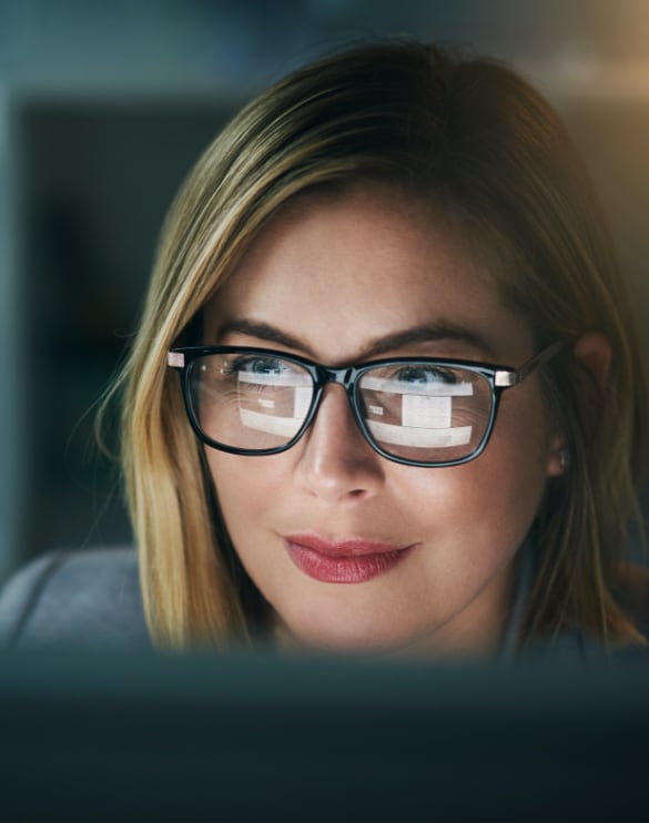 Close up image of a woman looking at computer screen.