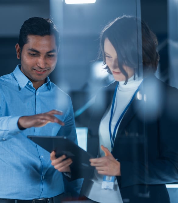 Man and woman reviewing information on a tablet device.