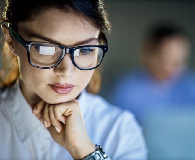 Close up image of a woman looking at computer screen.