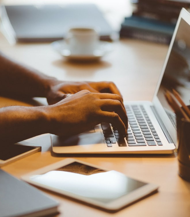 Close up image of a person typing on laptop keyboard.