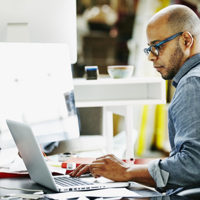 Close up image of a man looking at laptop screen.