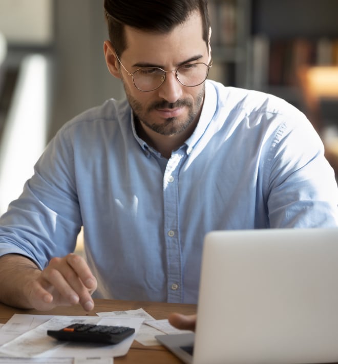 Close up image of a man typing on calculator.