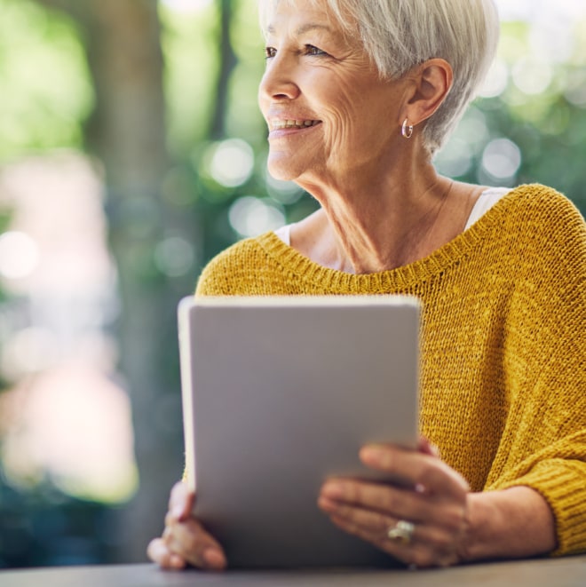 Close up image of a woman holding a tablet device.