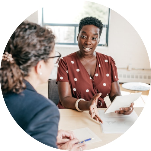 Two women having a conversation in an office.