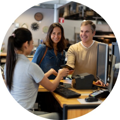 Customers at a home furnishings store checking out at a register using mobile device.