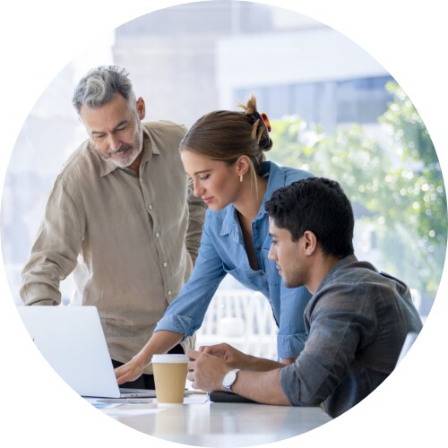 Group of business people reviewing information on laptop.