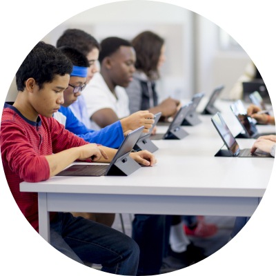 A group of high school students working on digital tablets in the computer lab of the school.