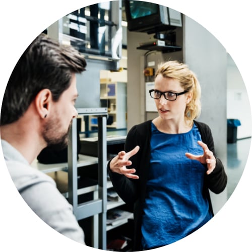 Young woman discussing project with a male coworker.