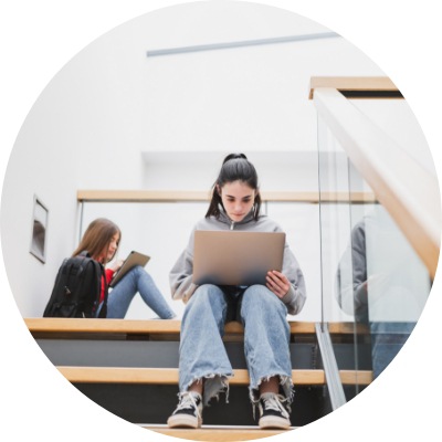 Girl sitting on the high school stairs studying with laptop.