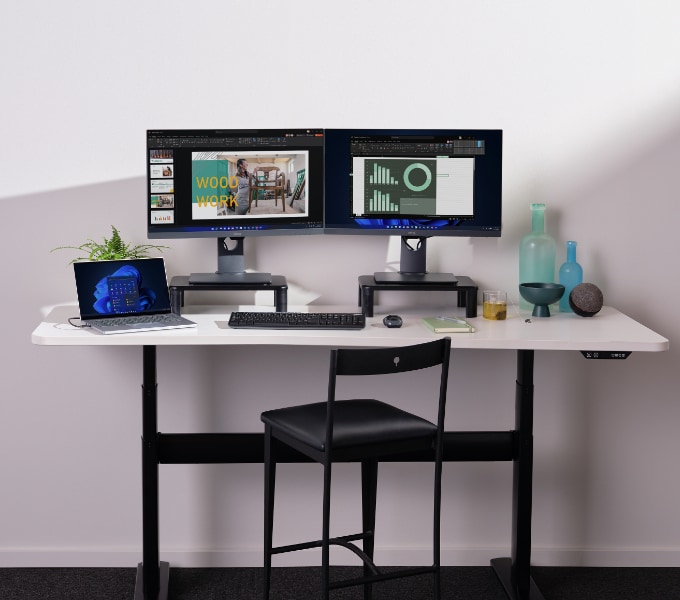 A work desk with two computer monitors in a home environment.