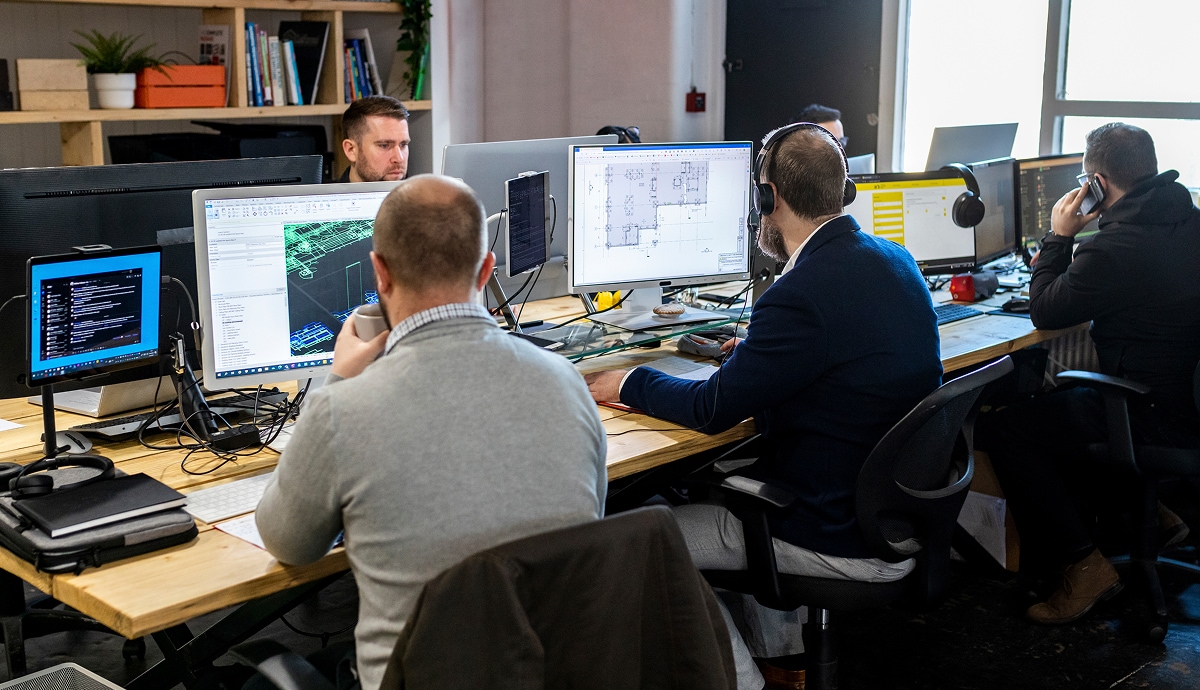 Team of professionals collaborating at computer workstations.