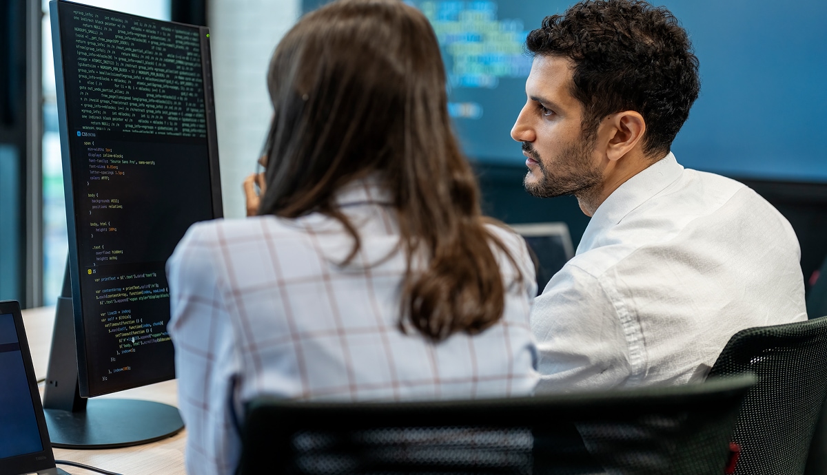 Colleagues reviewing a digital training module on a computer screen.