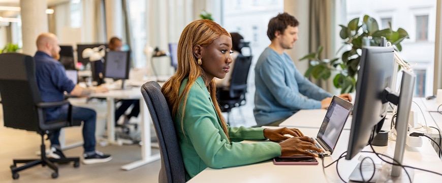 Young african woman sitting at her desk and working on computer