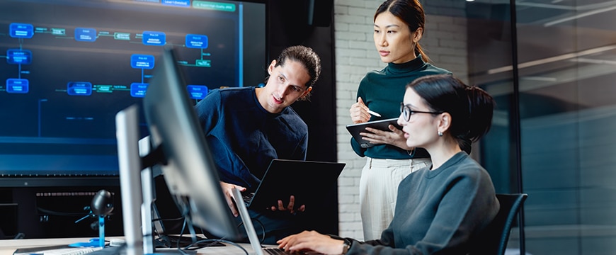 Programmers in a dark office discussing tokenomics.