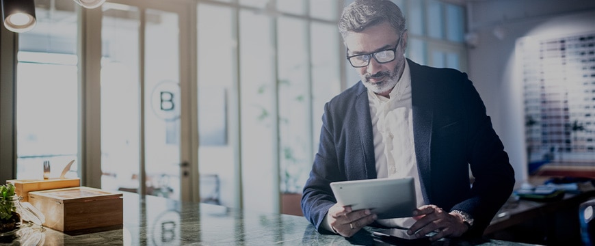 Mid adult man working using digital tablet