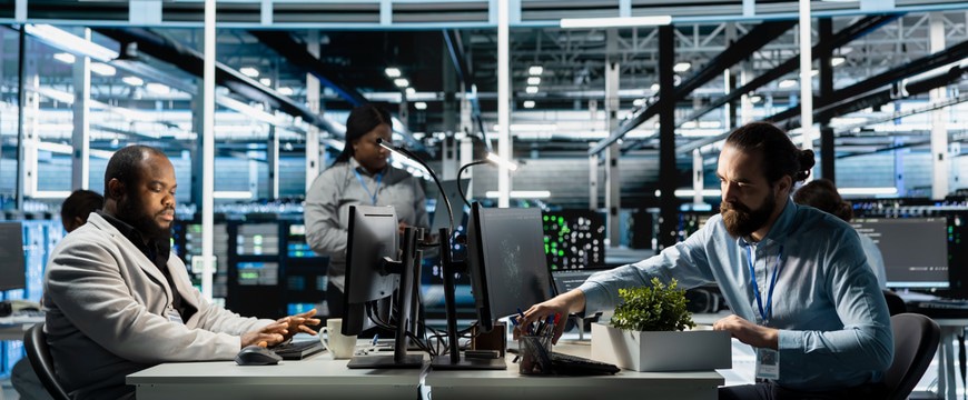 Team members working at computer workstations inside a modern data center