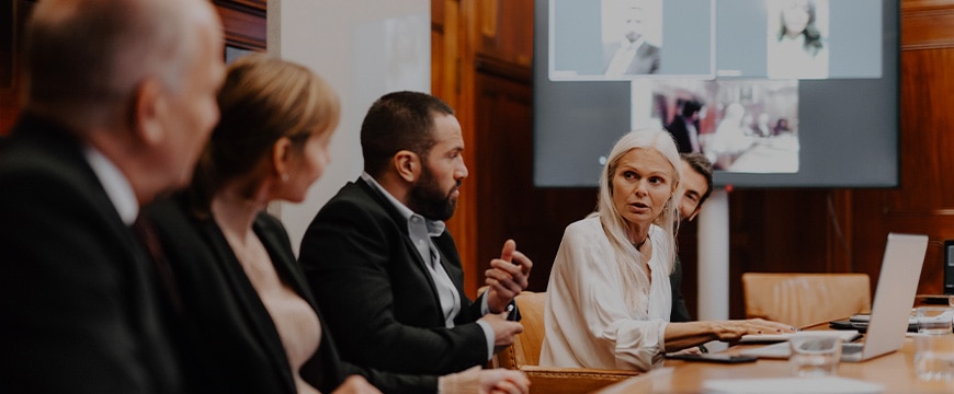 Female financial expert discussing with colleagues in meeting at board room