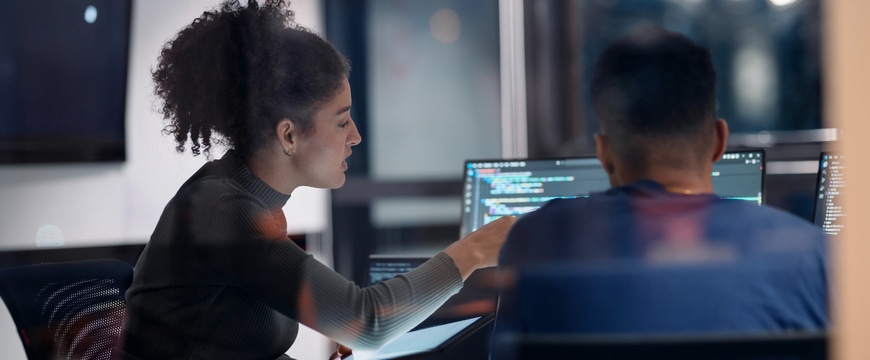 IT engineers working together in a server room with devices