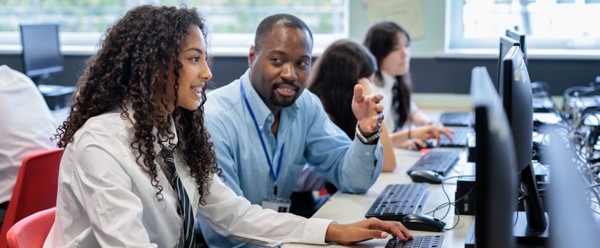 Techer student collaborating at desktop computers in a shared office workspace