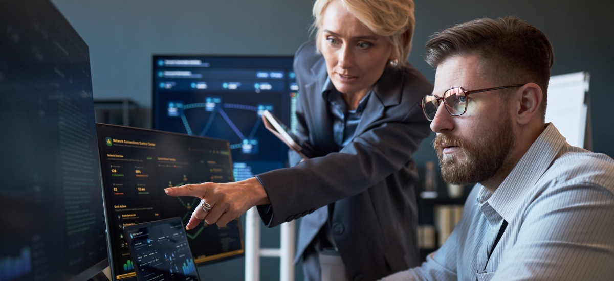 Enterprise team reviews AI workflow system setup on monitor screens.