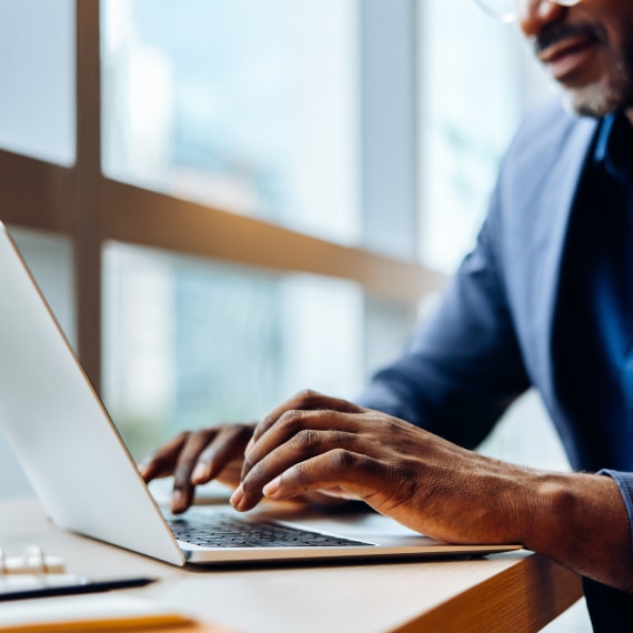 Professional uses a laptop to support integrated deployment strategy.