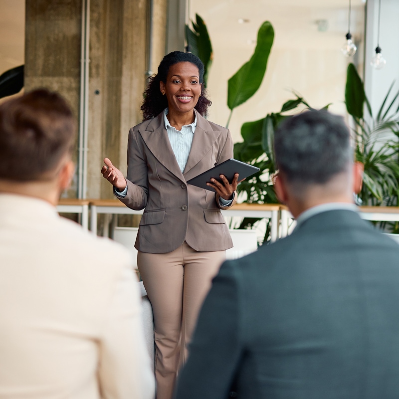 Professional presenting strategy with a tablet to colleagues in a modern office.