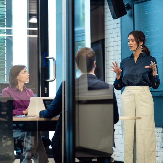 A presenter explains AI governance concepts to colleagues during a strategy meeting.