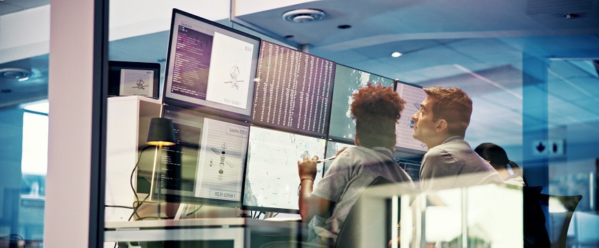 two people working in front of screens