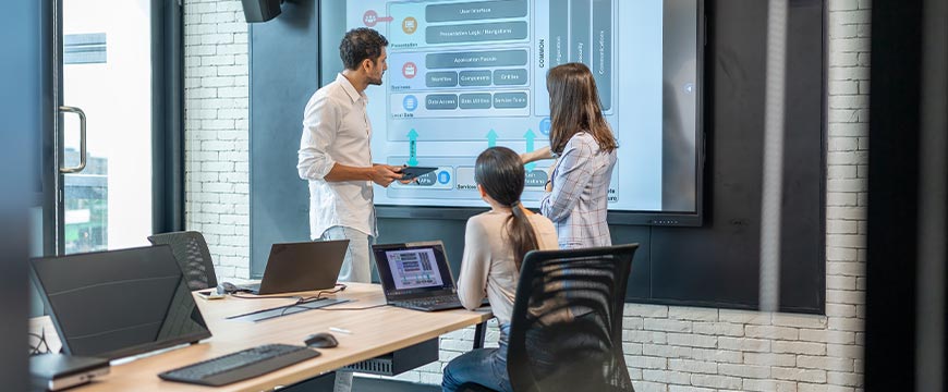 Man software developer presenting the Mobile Application Architecture Diagram on the large screen to developer team in meeting room.