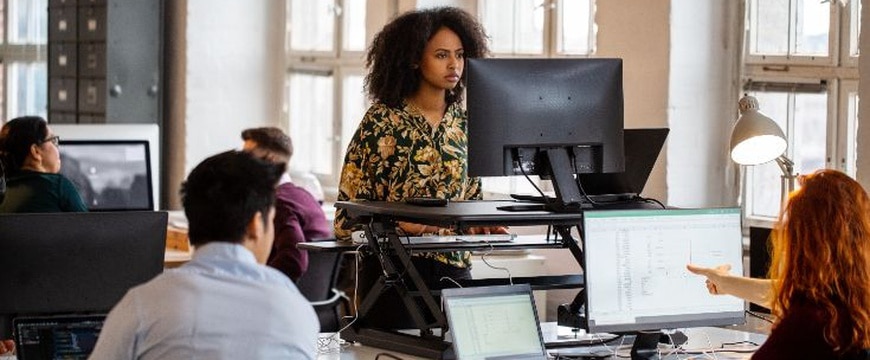 Employee using ergonomic desktop accessories in hybrid office environment