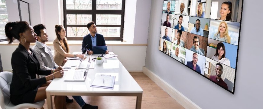 IT‑enabled meeting room with professionals collaborating on video call