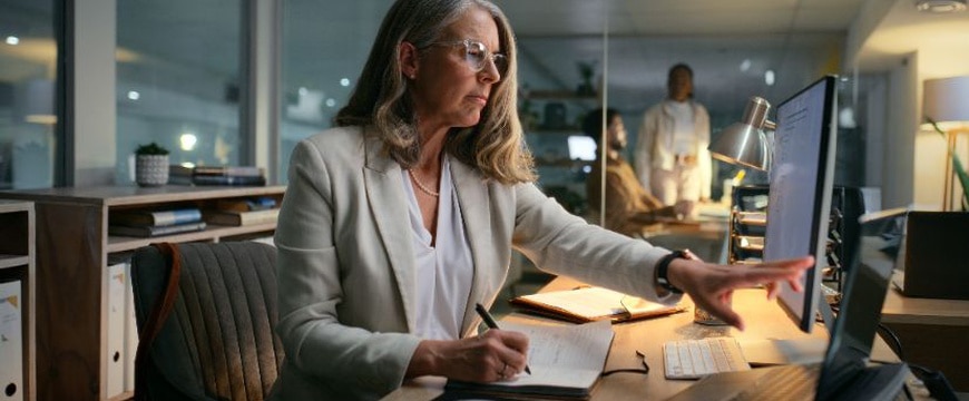 Business professional reviewing digital documents on laptop in modern office