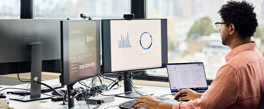 software developers working on multiple screens displaying code and application diagrams at night in modern office